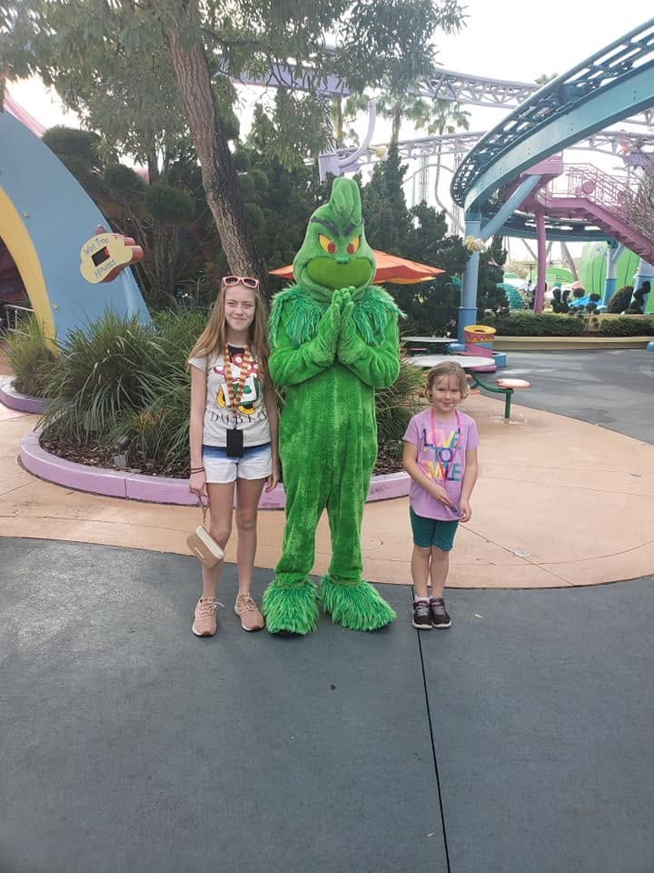Two children posing with the Grinch during a family outing