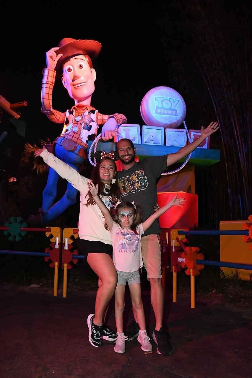 Two children posing with a Toy Story character during a family experience
